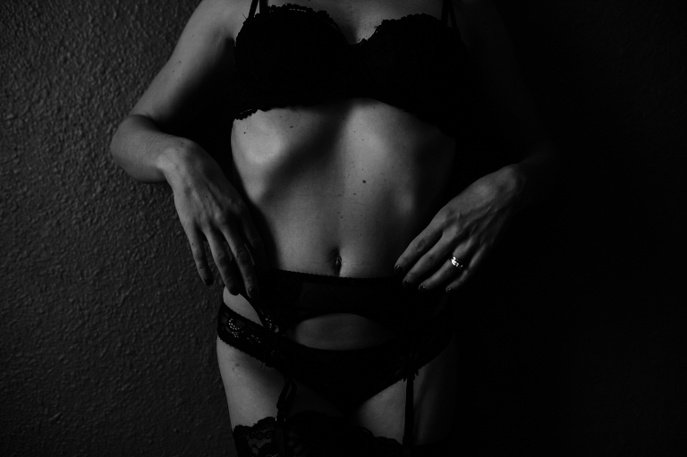 Woman with black lingerie posing for boudoir photos