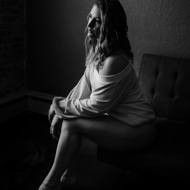 Woman wearing sweater top and undies in boudoir shoot