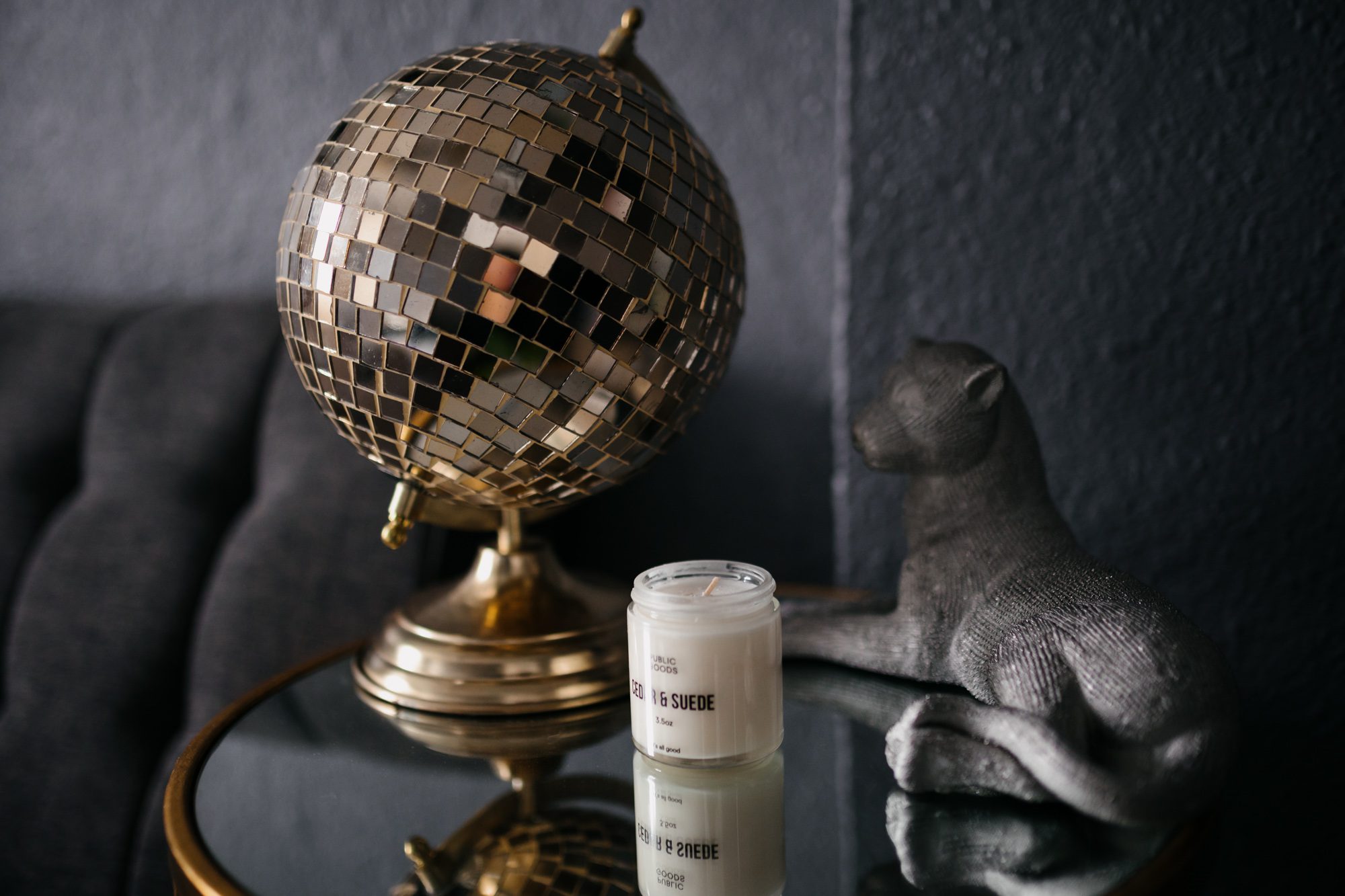 Disco ball and candle on mirrored table