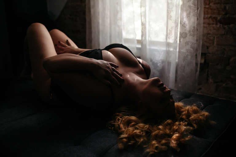 Woman laying on back during Denver boudoir session