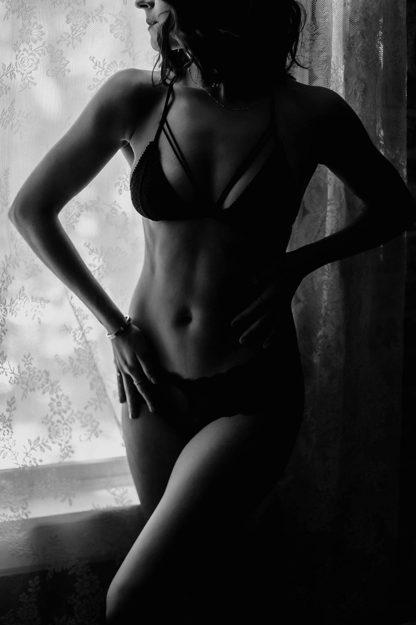 Real Denver boudoir client standing in window
