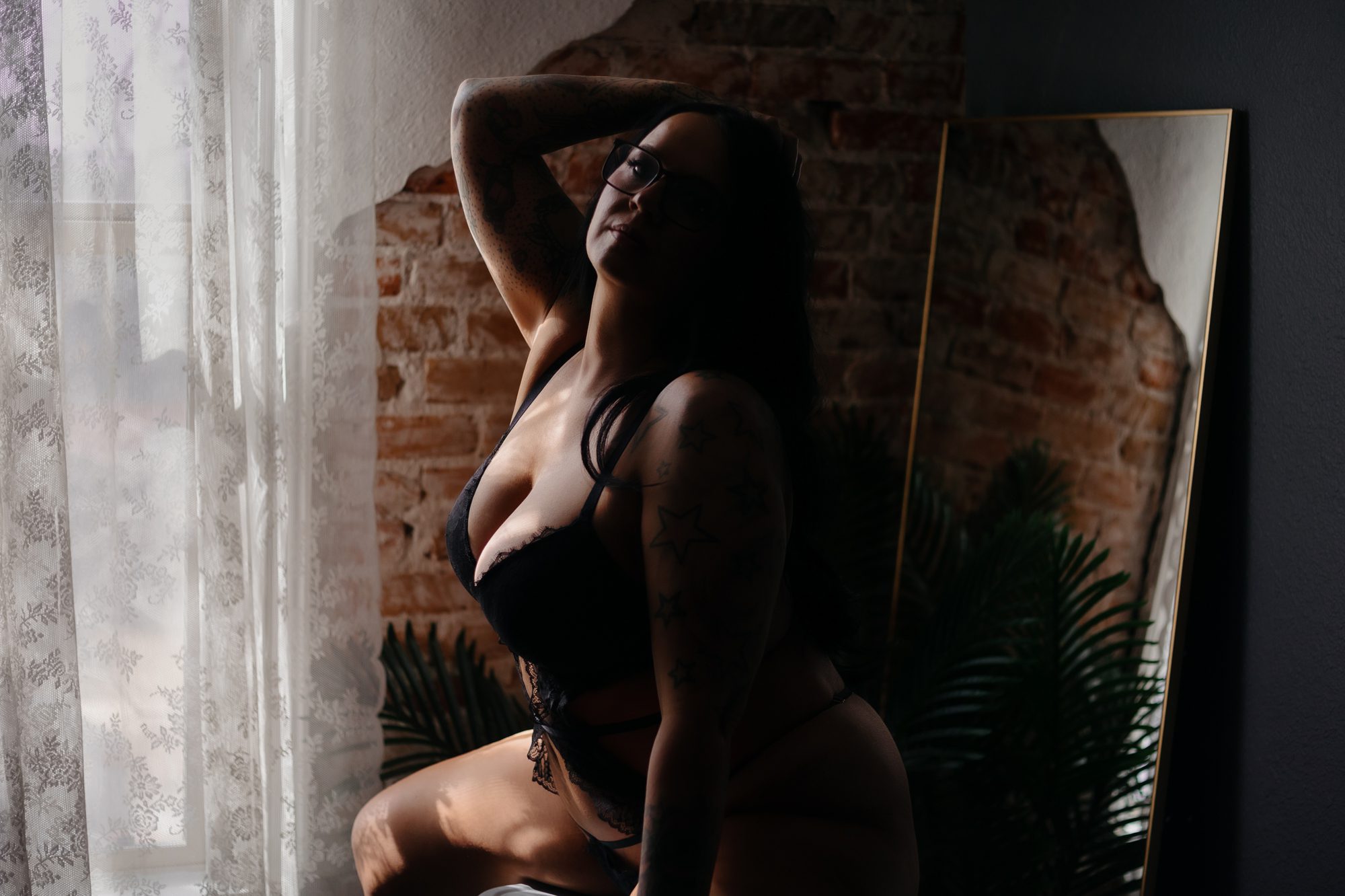 Real life boudoir client wearing glasses during boudoir photo shoot